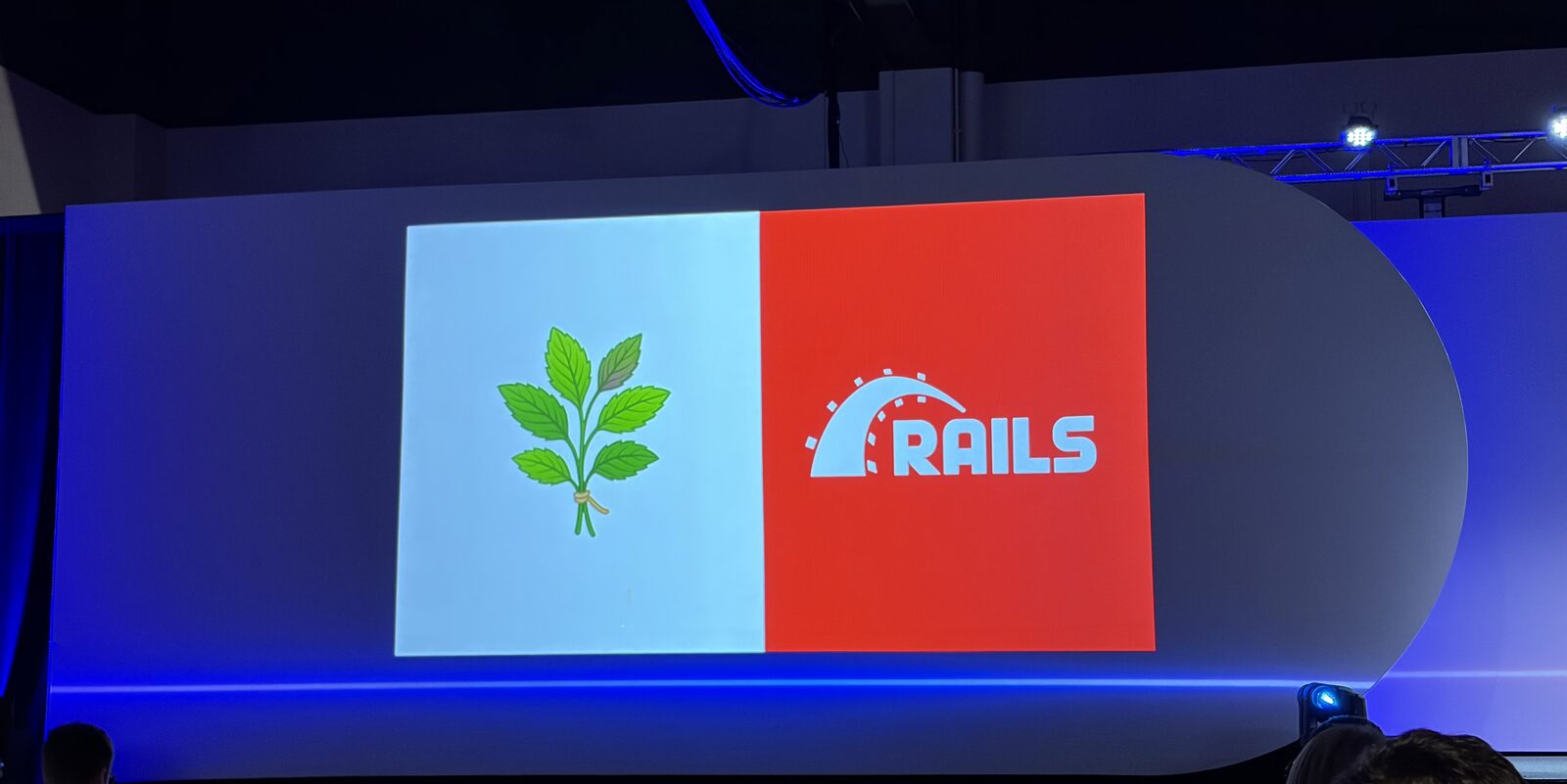 A slide from the talk showing a sprig of herb leaves next to the Ruby on Rails logo, split down the middle like a two-color flag
